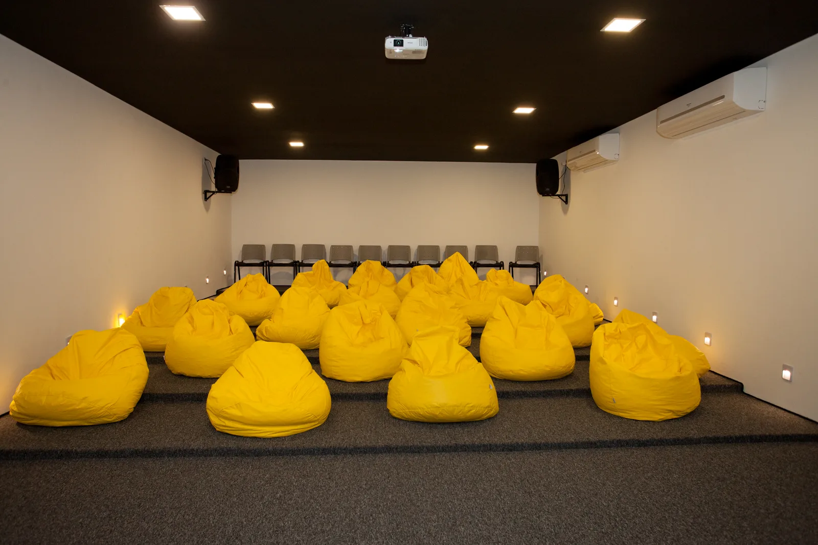Auditório Minions com puffs amarelos em uma montagem alternativa
