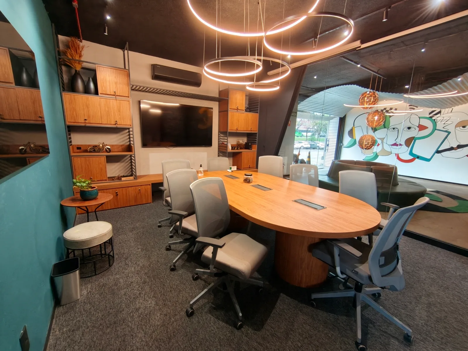 Sala Business com mesa de reunião e luminárias circulares